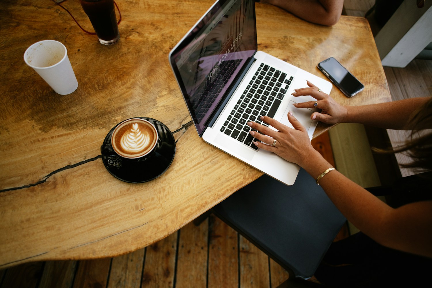 Laptop and coffee on a wooden table, illustrating SEO migration consultant services