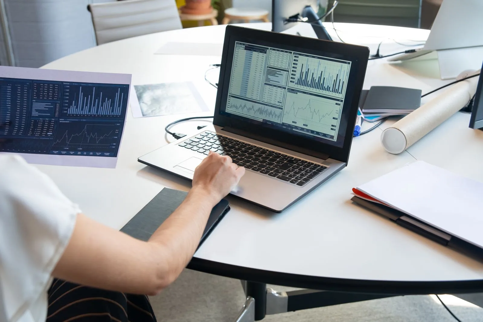 Person reviewing laptop charts and a printed report, illustrating a technical SEO audit service